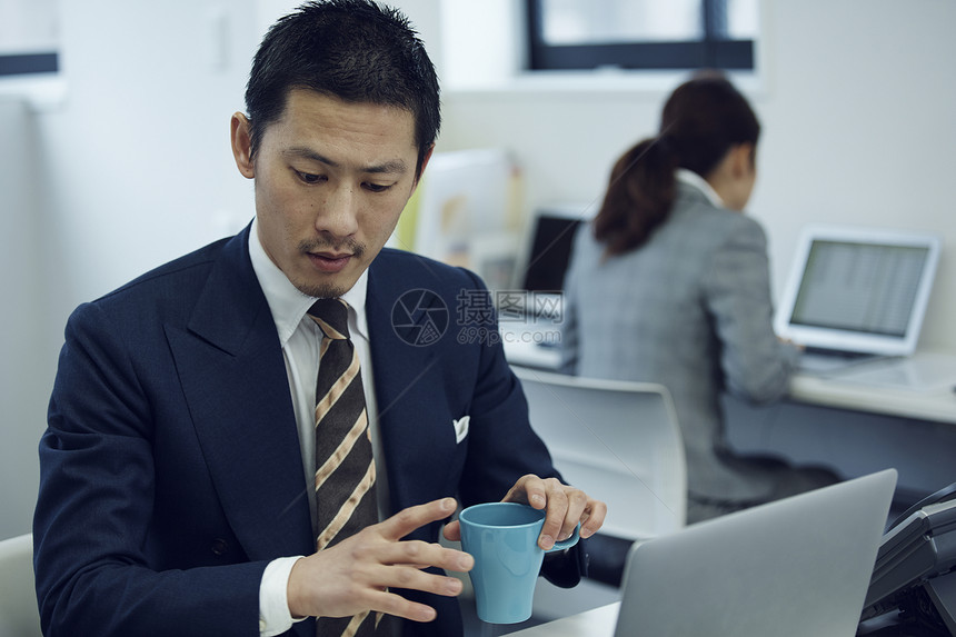 手拿水杯的男商人图片