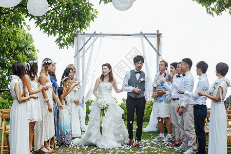 一对受到朋友庆祝的新婚夫妇举行花园婚礼仪式高清图片素材