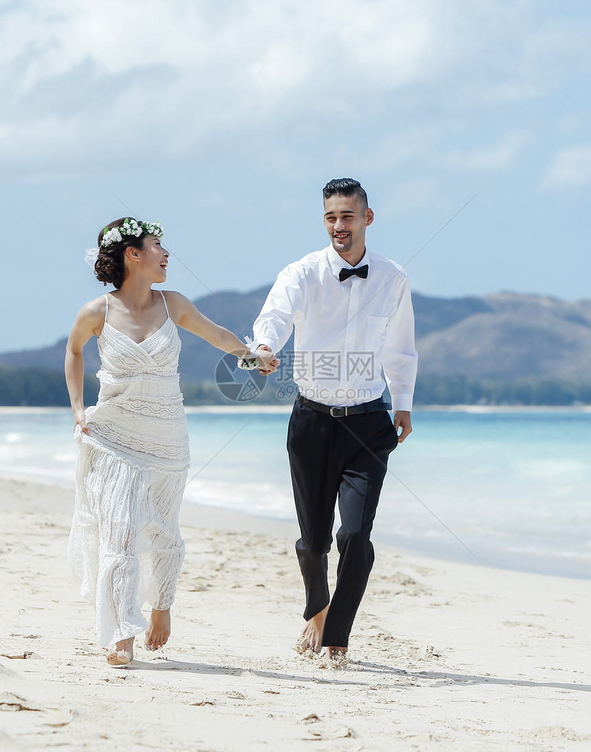 新婚夫妇走在海滩上图片