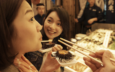 吃夜市美食的女性图片