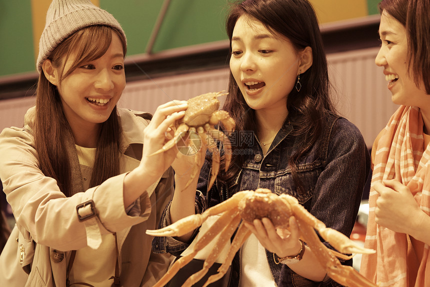 妇女在生猛海鲜观光市场挑选螃蟹图片
