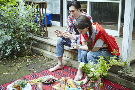 在户外野餐享受美食的年轻夫妻高清图片