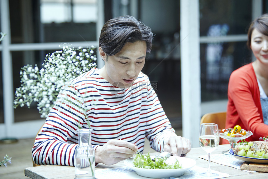 年轻夫妻在户外餐桌上享受美食图片