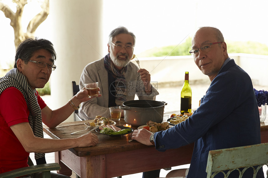三个年长的男人享受家庭美食聚会图片