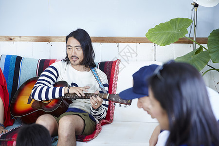假日家庭聚会弹吉他的男性图片