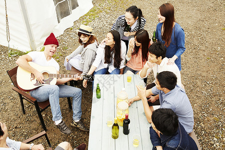 参加户外烧烤派对的年轻人弹吉他唱歌图片