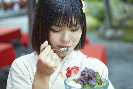 穿着日式服装的女孩吃沙冰背景图片