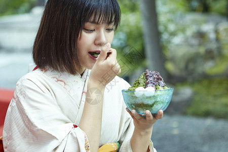 穿着日式服装的女孩吃沙冰背景图片