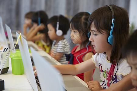 带着耳机学习的幼儿园学生女孩高清图片素材