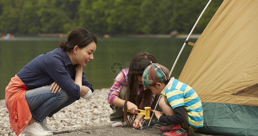 湖边教儿女搭帐篷的妈妈图片