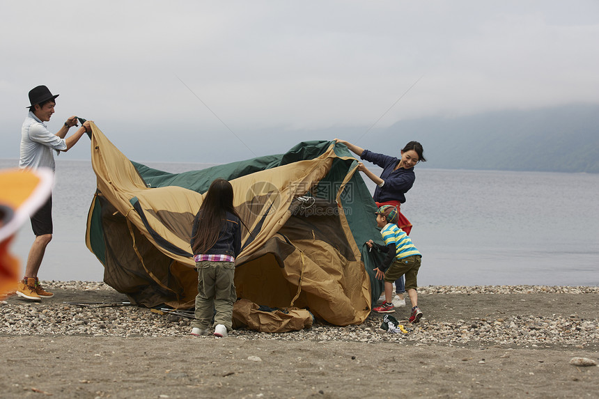 湖边搭帐篷的四口家庭图片