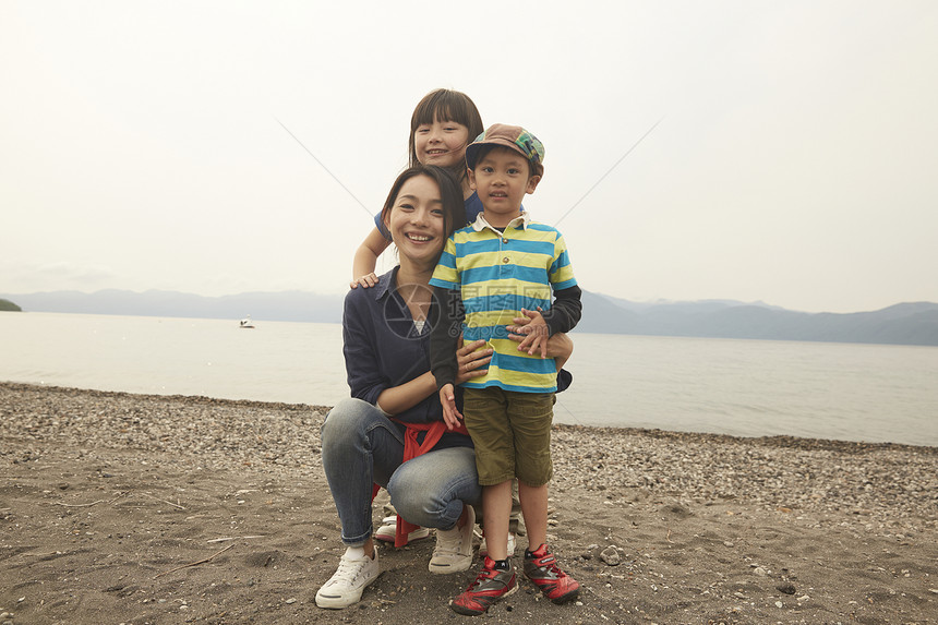 假期湖边玩耍的母亲与孩子们的全家福图片
