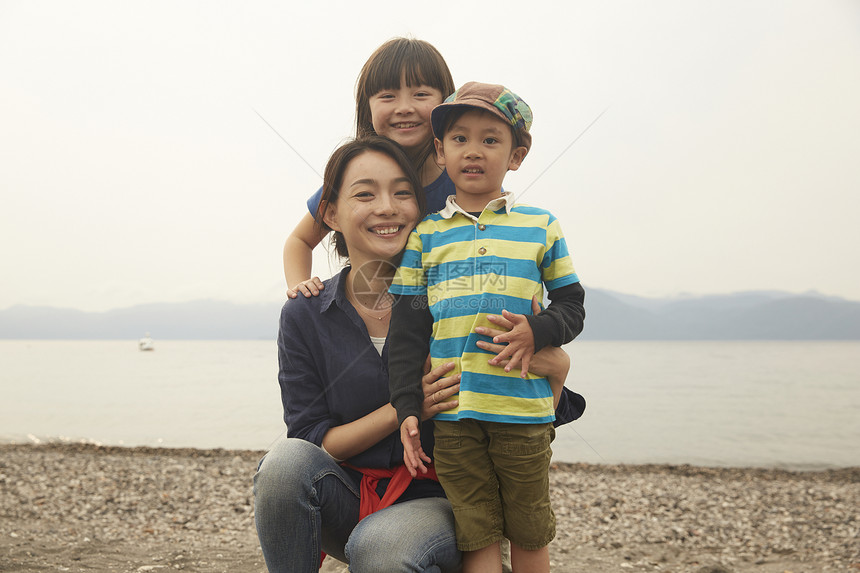 在湖边快乐旅游的3人看镜头图片