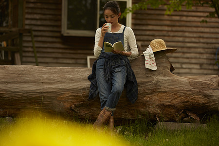 农田旁喝茶看书休息的女孩画像图片