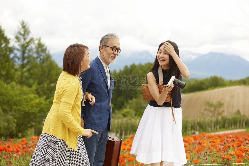 女儿带着年迈的爸爸在花田里看风景图片