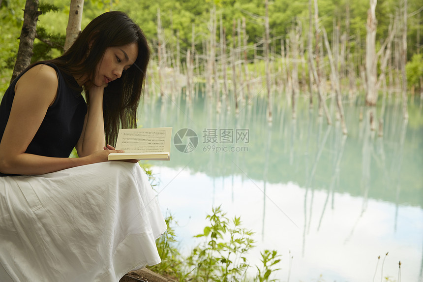 一个女人悠哉的在湖边看书图片