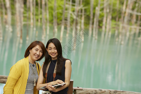 在湖边拍照留念的母女亲密朋友高清图片素材