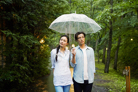 雨天撑伞漫步林间的情侣图片