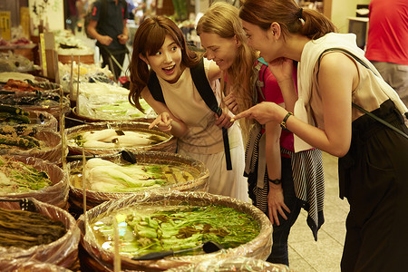 年轻美女带外国友人当地市场旅游观光姐妹出游高清图片素材