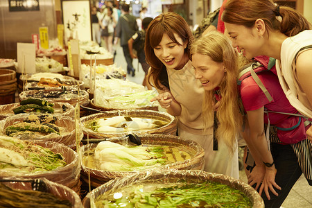 年轻美女带外国友人当地市场旅游观光白领高清图片素材