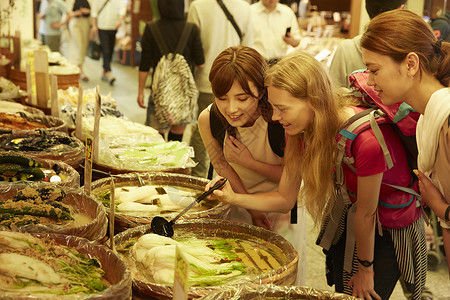 外国旅客体验当地市场美食晴朗高清图片素材