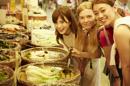 年轻美女带外国友人当地市场旅游观光形象休息高清图片素材