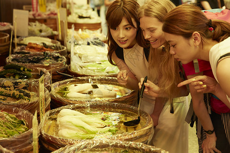 年轻美女带外国友人当地市场旅游观光日本人高清图片素材