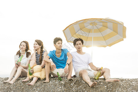 坐在海滩的上的青年情侣图片