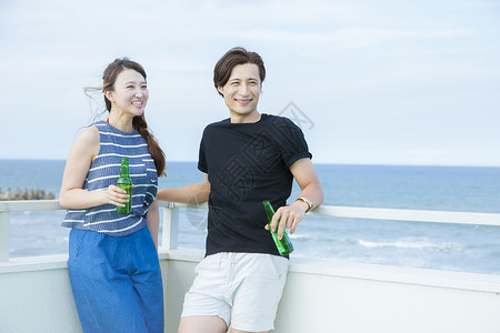 海边喝酒聊天的情侣图片