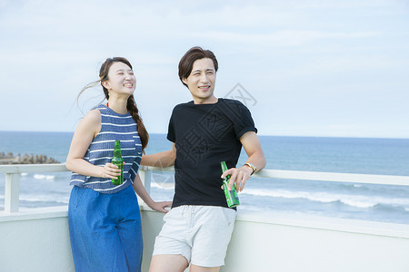 海边度假喝酒的青年情侣图片
