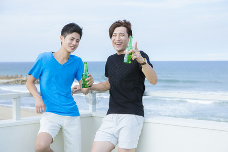 海边喝酒聊天的男性图片