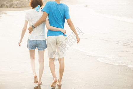 海滩边散步的情侣背影图片