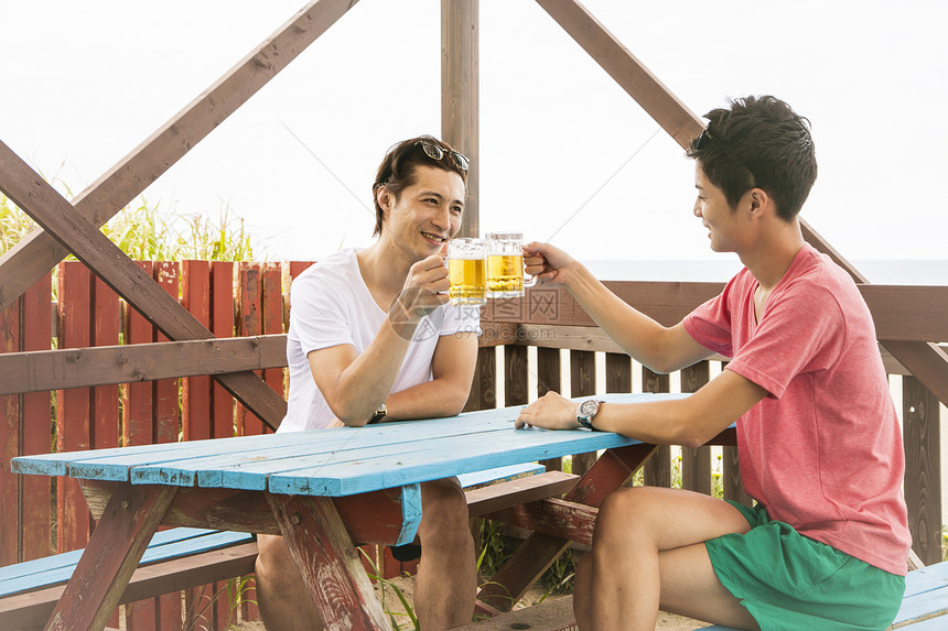 餐厅里男人海边度假喝啤酒图片