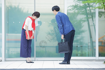 摩登素材背景楼前互相礼貌鞠躬的男女背景