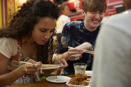 快乐的外国游客享受日本料理图片