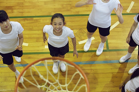 学校体育馆内女高中学生打篮球年轻高清图片素材