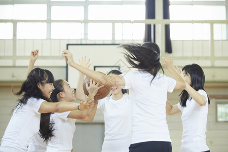 学校体育馆内女高中学生打篮球伙伴高清图片素材