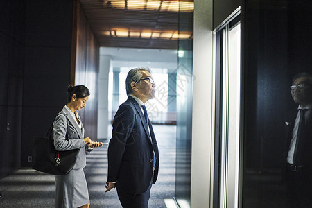 走进办公楼电梯厅的商务人士图片