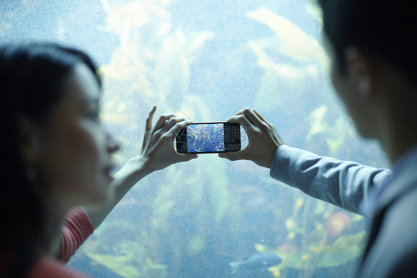 年轻情侣在水族馆约会拍照图片