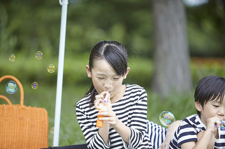 小孩野餐玩耍吹泡泡图片