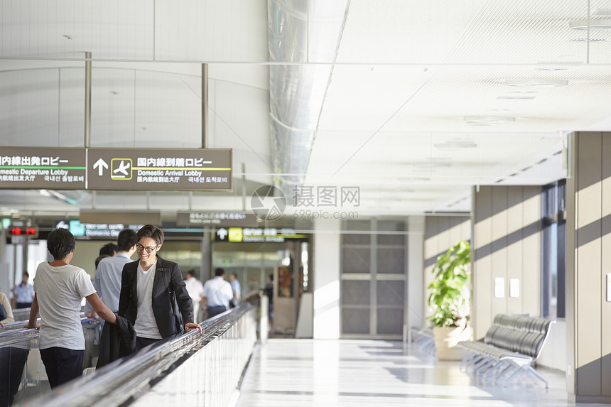 男子走在机场电梯图片