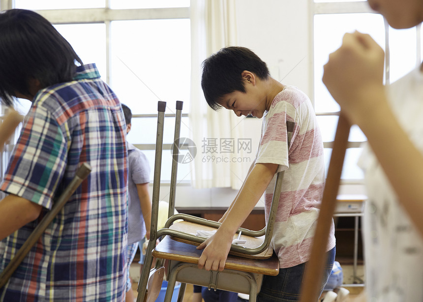 用力抱起自己课桌椅的男生图片