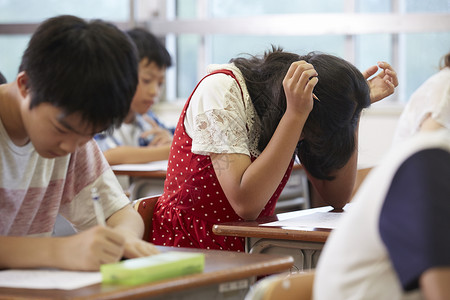 考试埋头思考的学生证明高清图片素材