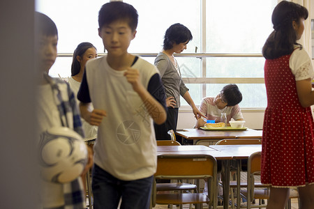 课间老师督促学生吃饭背景图片