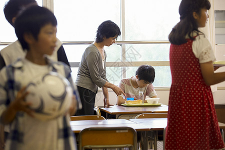 小学教室吃午餐的学生和老师小朋友高清图片素材