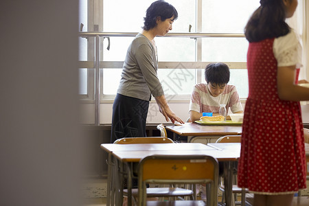 小学教室吃午餐的学生和老师儿童高清图片素材