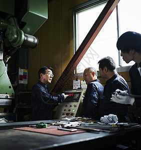 技术人员给工人介绍机器操作图片