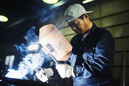 工厂内男子进行焊接操作图片