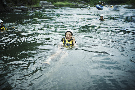穿着救生衣在水里浮着的女青年女性高清图片素材