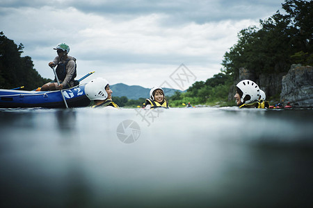 划着橡皮艇享受运动的男女青年度假高清图片素材